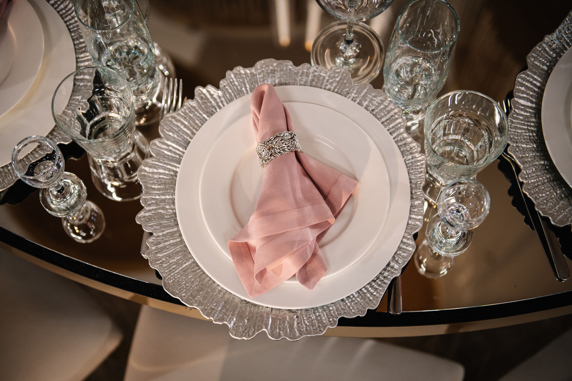 Serving, setting table. Plate decorated linen pink napkin and silverware cutlery, glasses. Top view. Closeup. Wedding set up, dinner table reception. Birthday, baptism, event. Luxury silver decor.