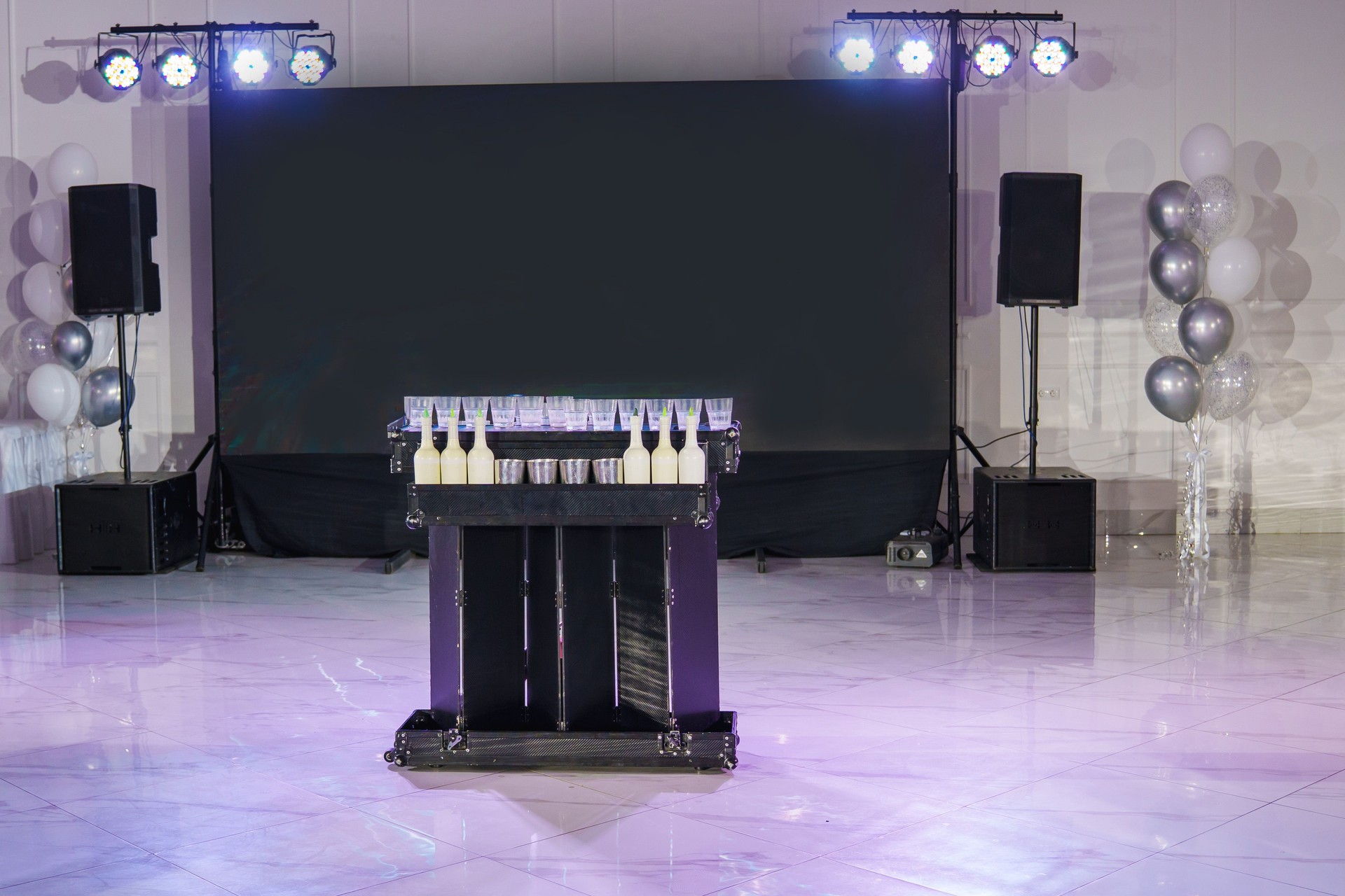 Elegant party setup with a drink station and balloons in a festive hall