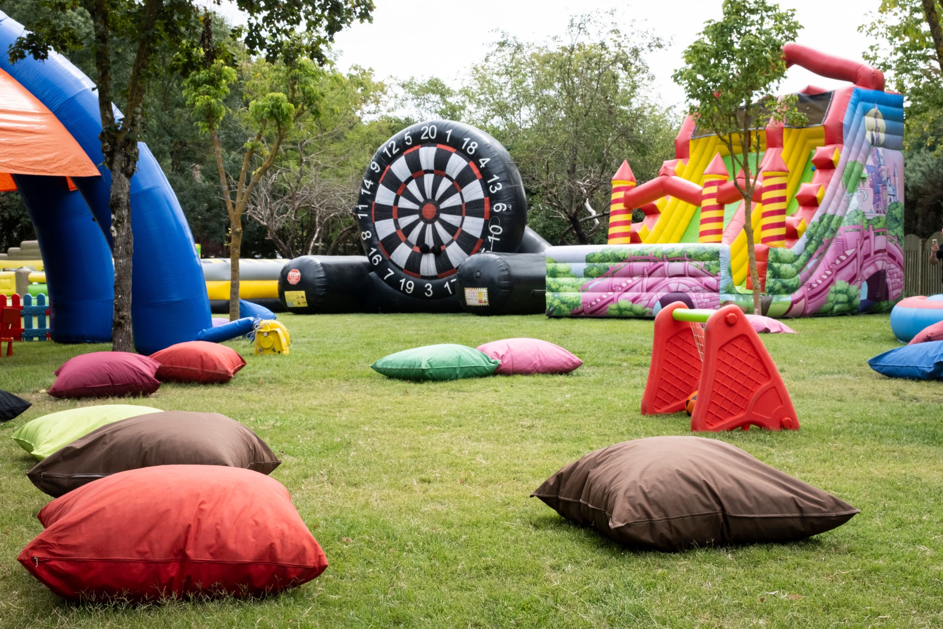 A large inflatable obstacle course is set up in a grassy field