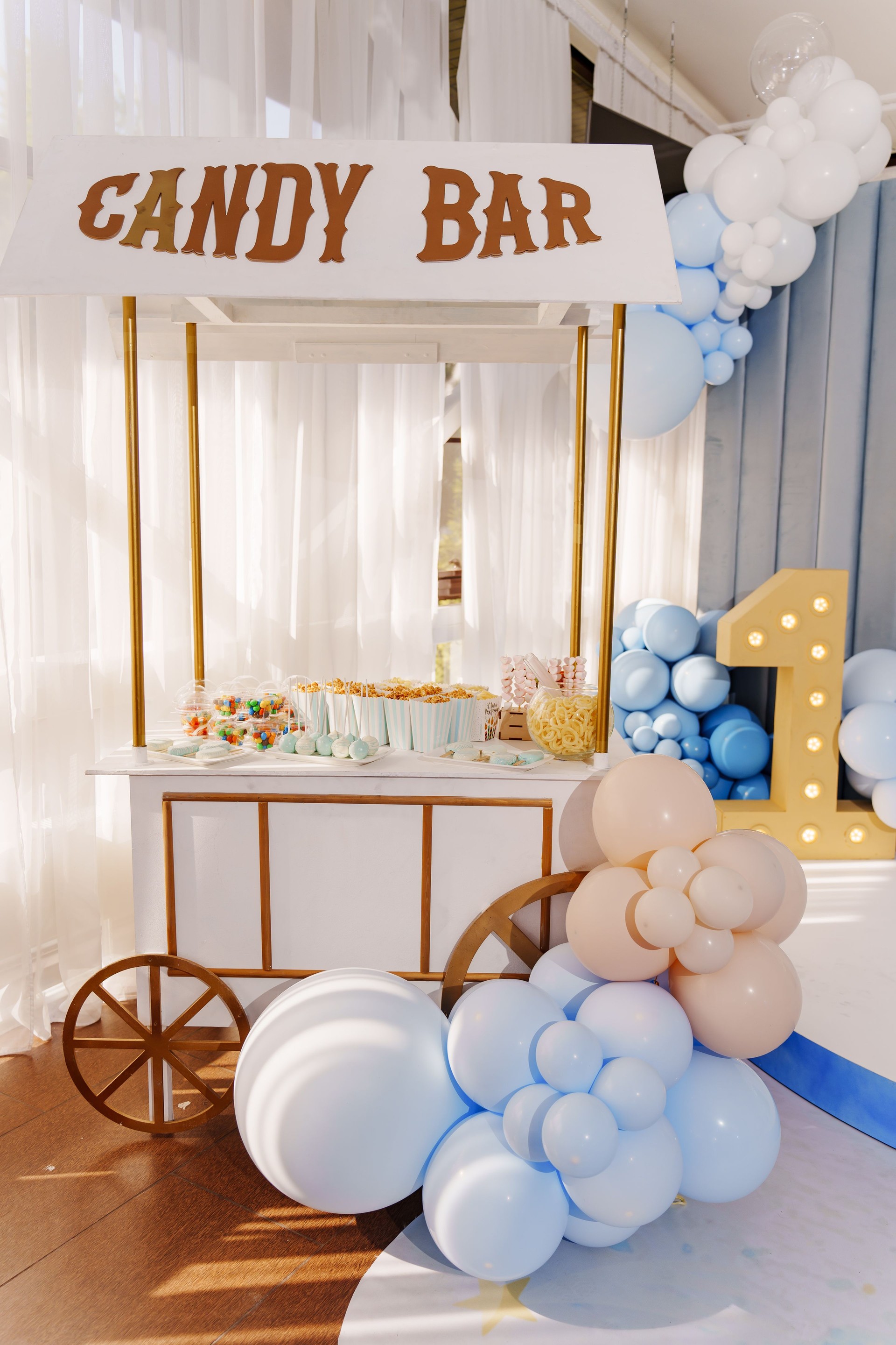 Little boy baby birthday decor with white and blue balloons.