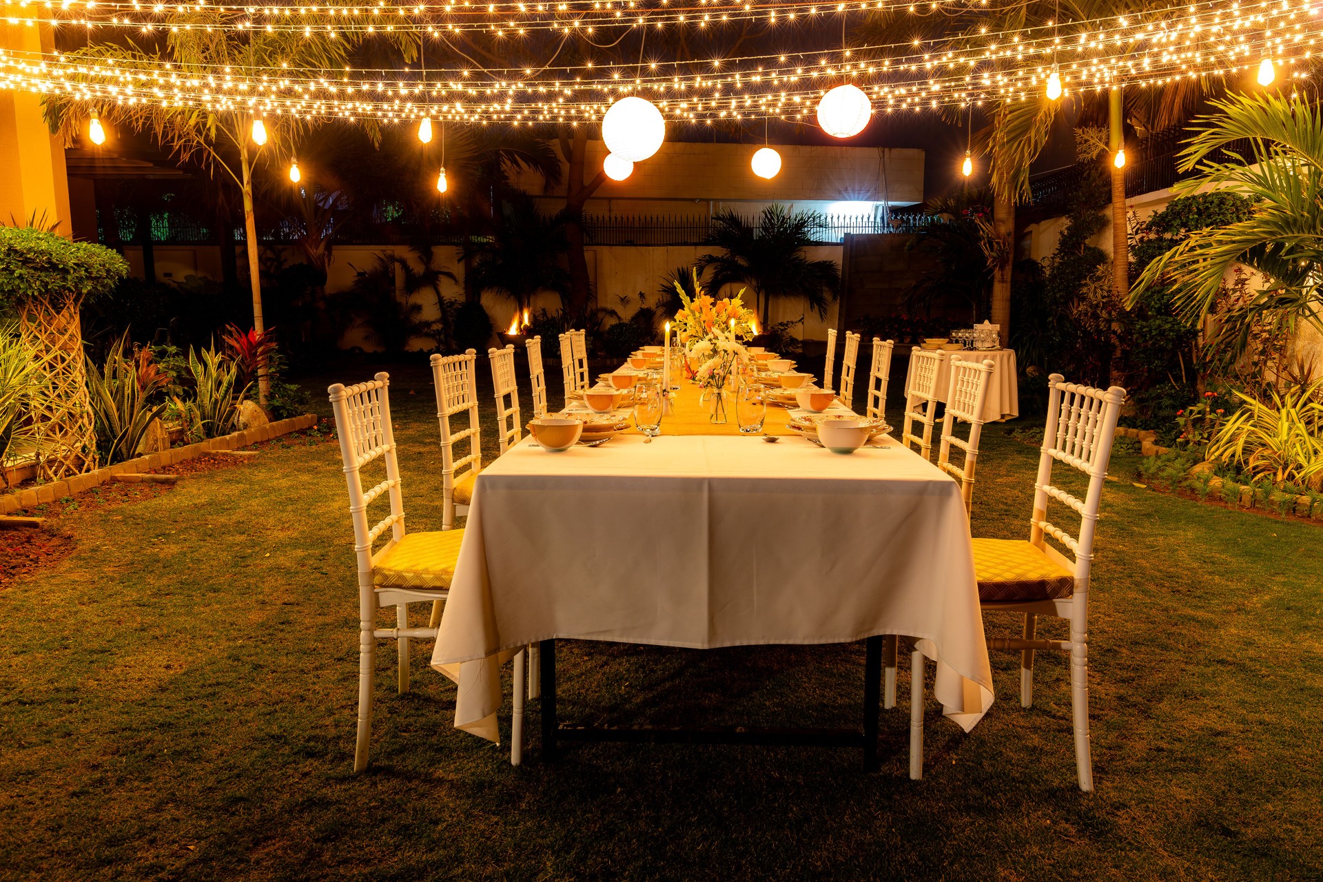 Summer winter candle light dinner party theme with fine dinning arrangements fairy lights and latrines in garden!