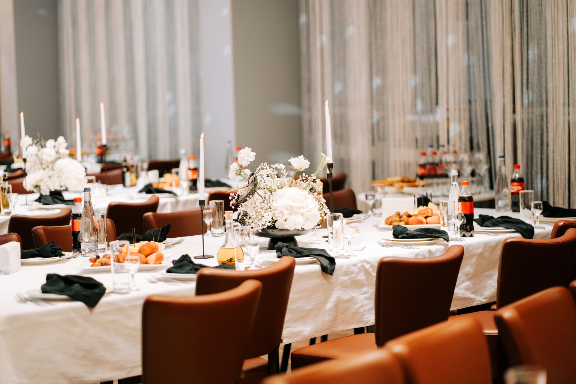 Elegant dining setup with floral centerpieces and food arranged for a formal gathering